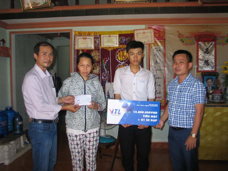 Đại diện Báo Thanh Niên (trái) và đại diện Công ty ITL trao tiền và quà cho mẹ con chị Nhàn /// Ảnh: CTV